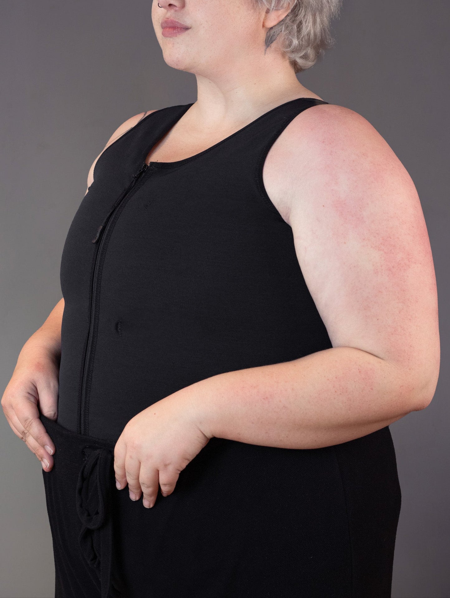 Nonbinary model Jeannette models a binder that can be worn with chronic pain, in the color black.