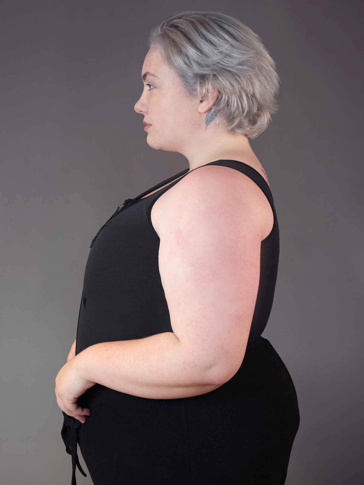 Side profile view of model Jeannette wearing a binder for big chest.