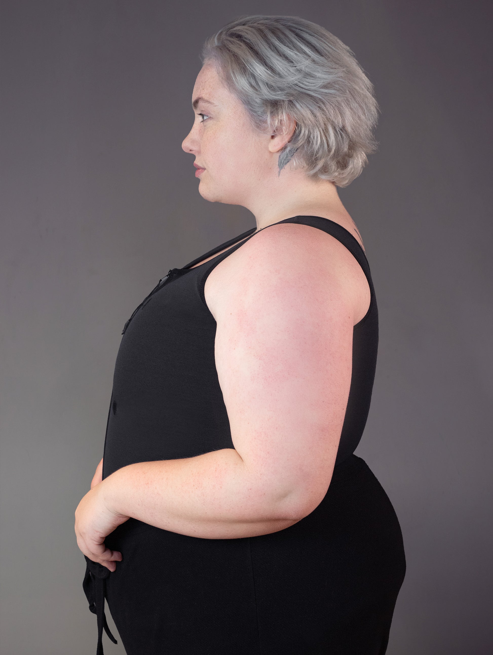 Side profile view of model Jeannette wearing a binder for big chest.