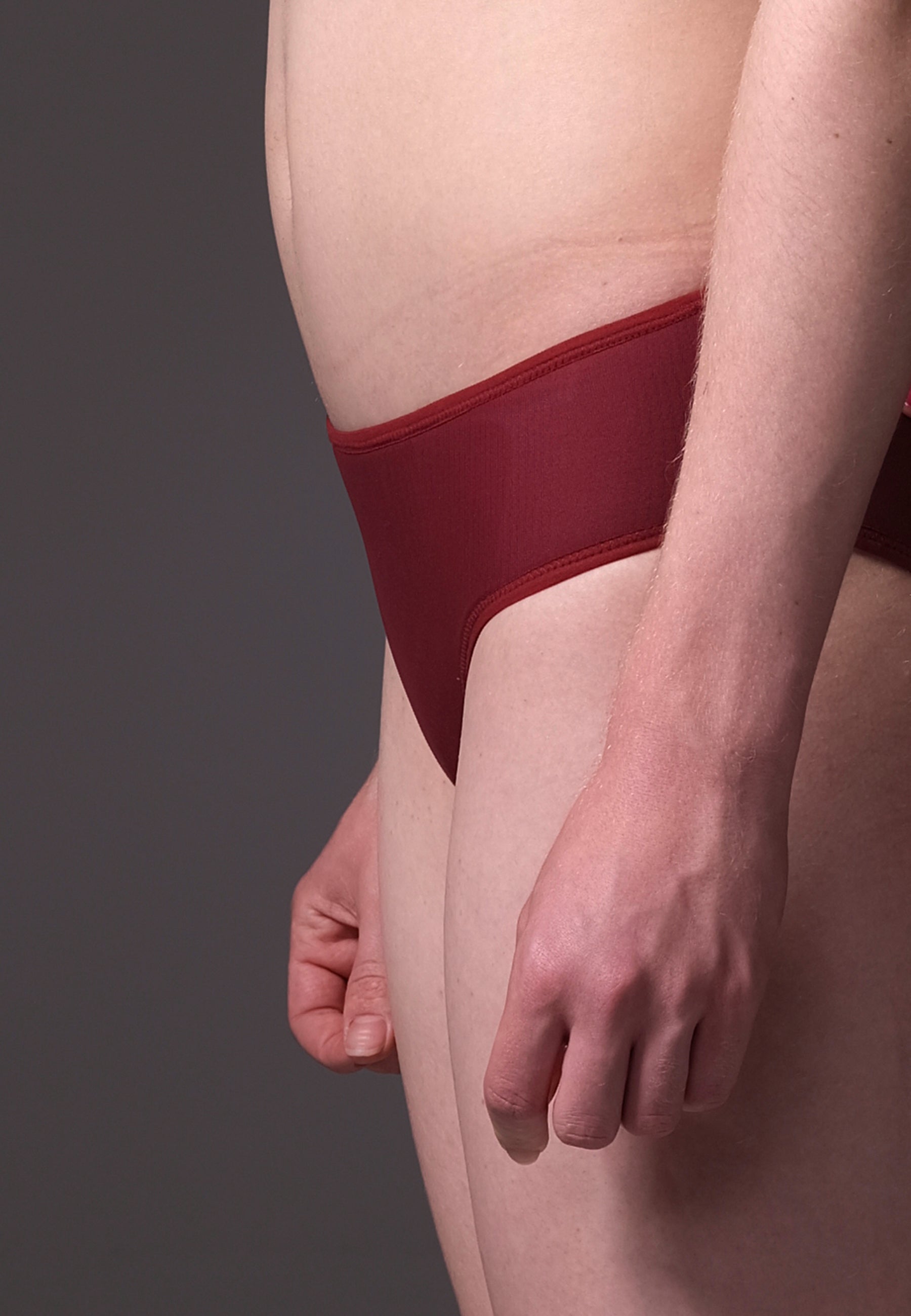Red underwear worn by a person on a gray background