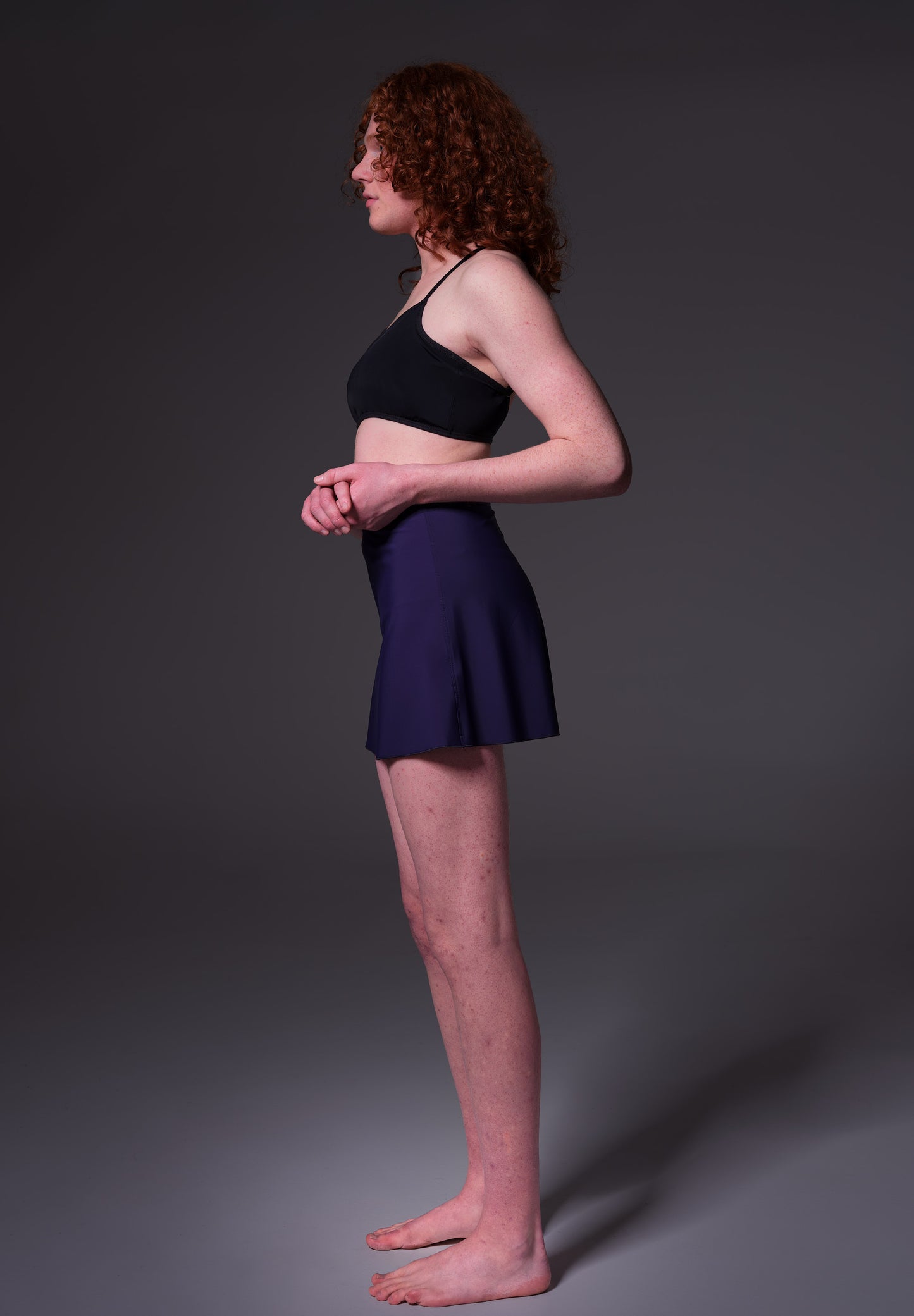 Model Sweder is seen from the side, wearing the Swim Skirt dark blue