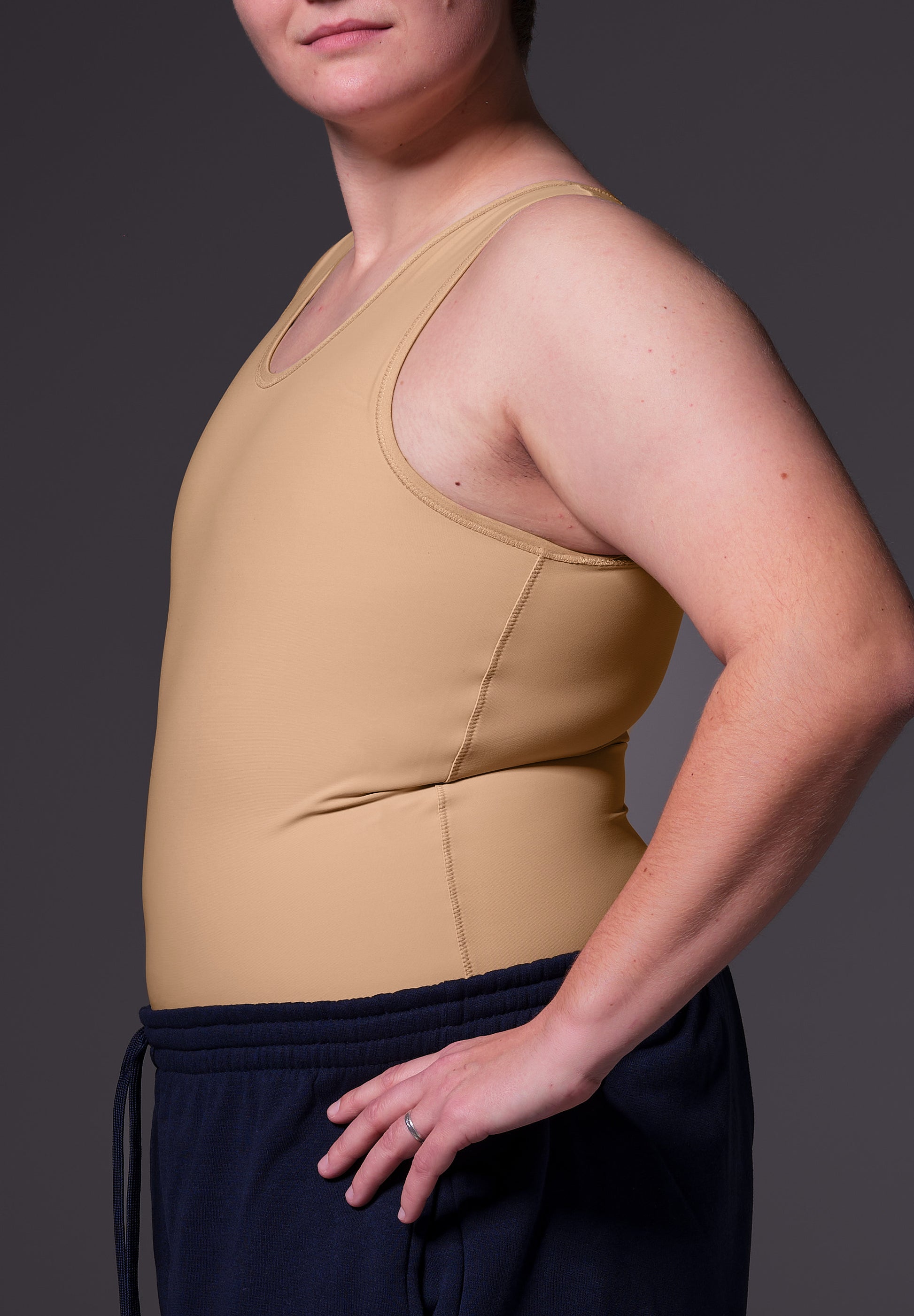 Deven is wearing the Shirt Binder in the color Caramel, seen from the side