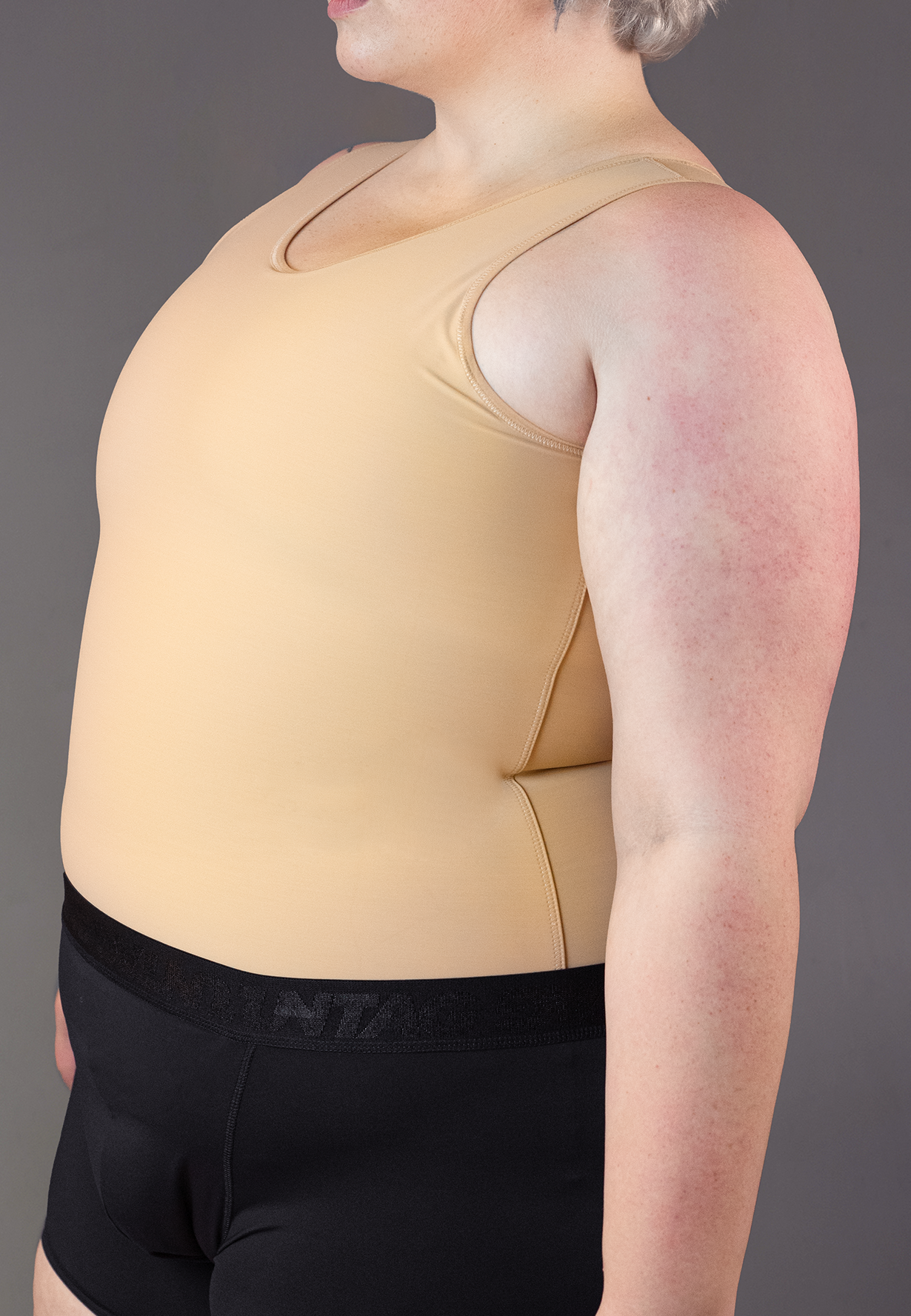 Jeannette is wearing the Shirt Binder in the color Caramel, seen from the side