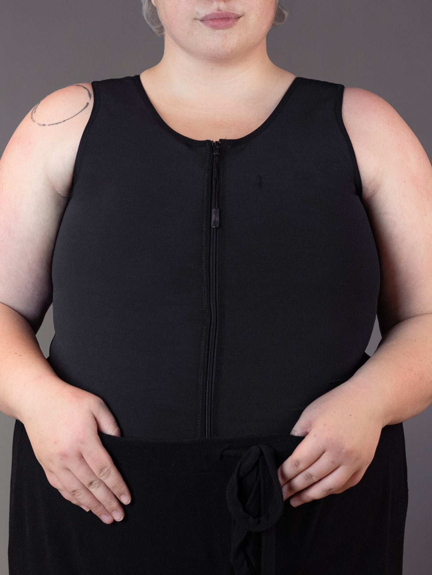 Genderqueer model Jeannette wears the Singlet Binder Zipper (asthma binder).