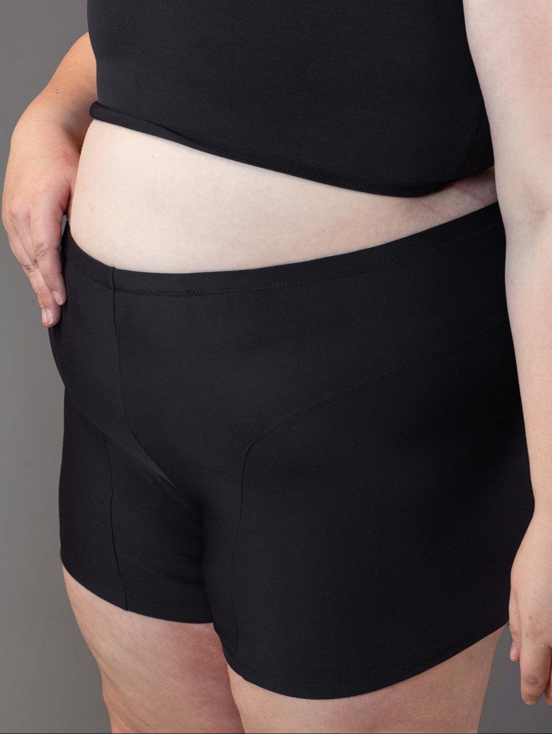 Plus size non binary model wears packer swim shorts.