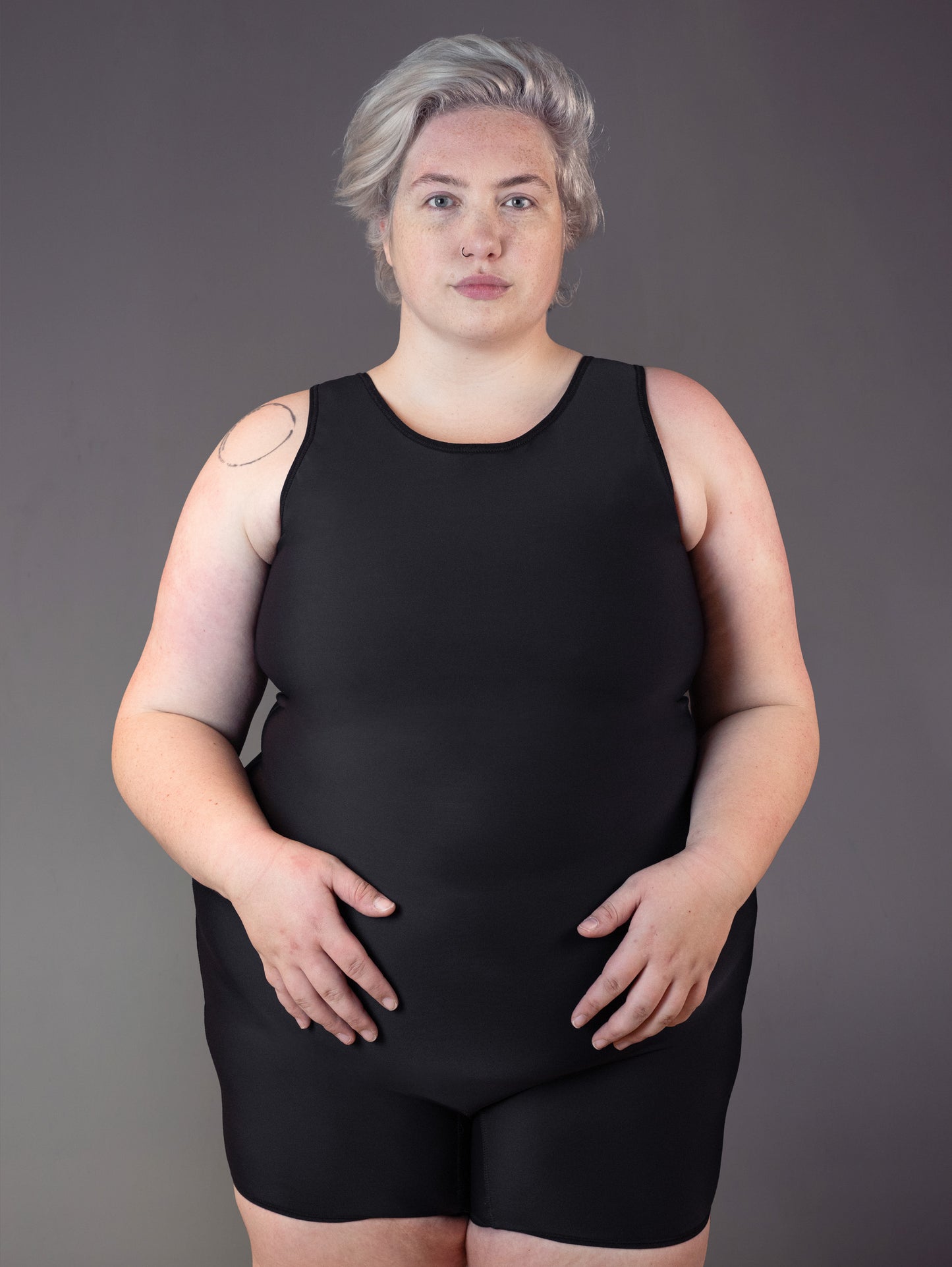 Non binary model wears the Swimsuit Binder for swimming.