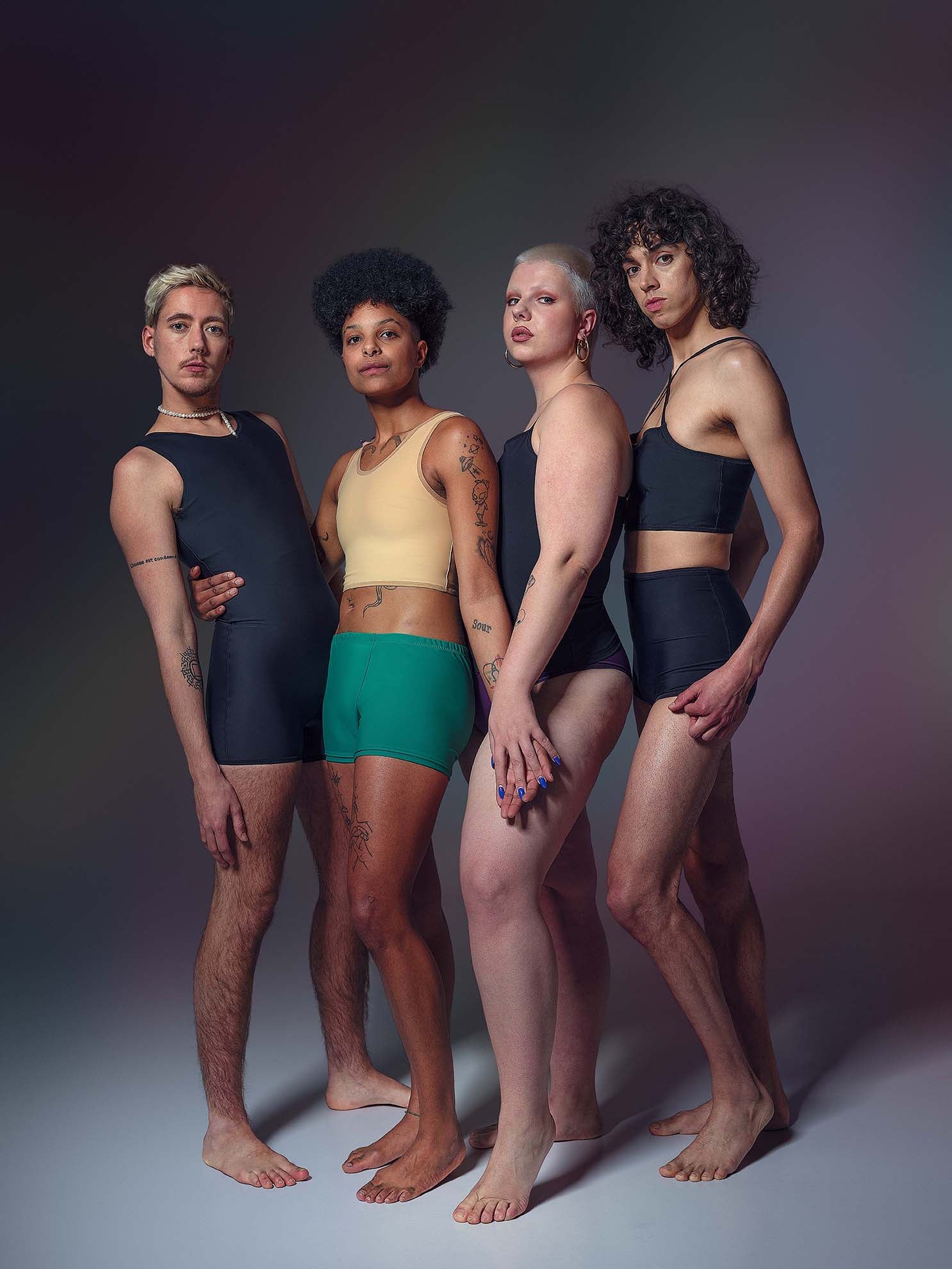 Our group of nonbinary, trans / transgender and transfem models. They are wearing our trans swimwear, chest binders, tucking undies and trans bikinis and they look wonderful! They are holding hands.