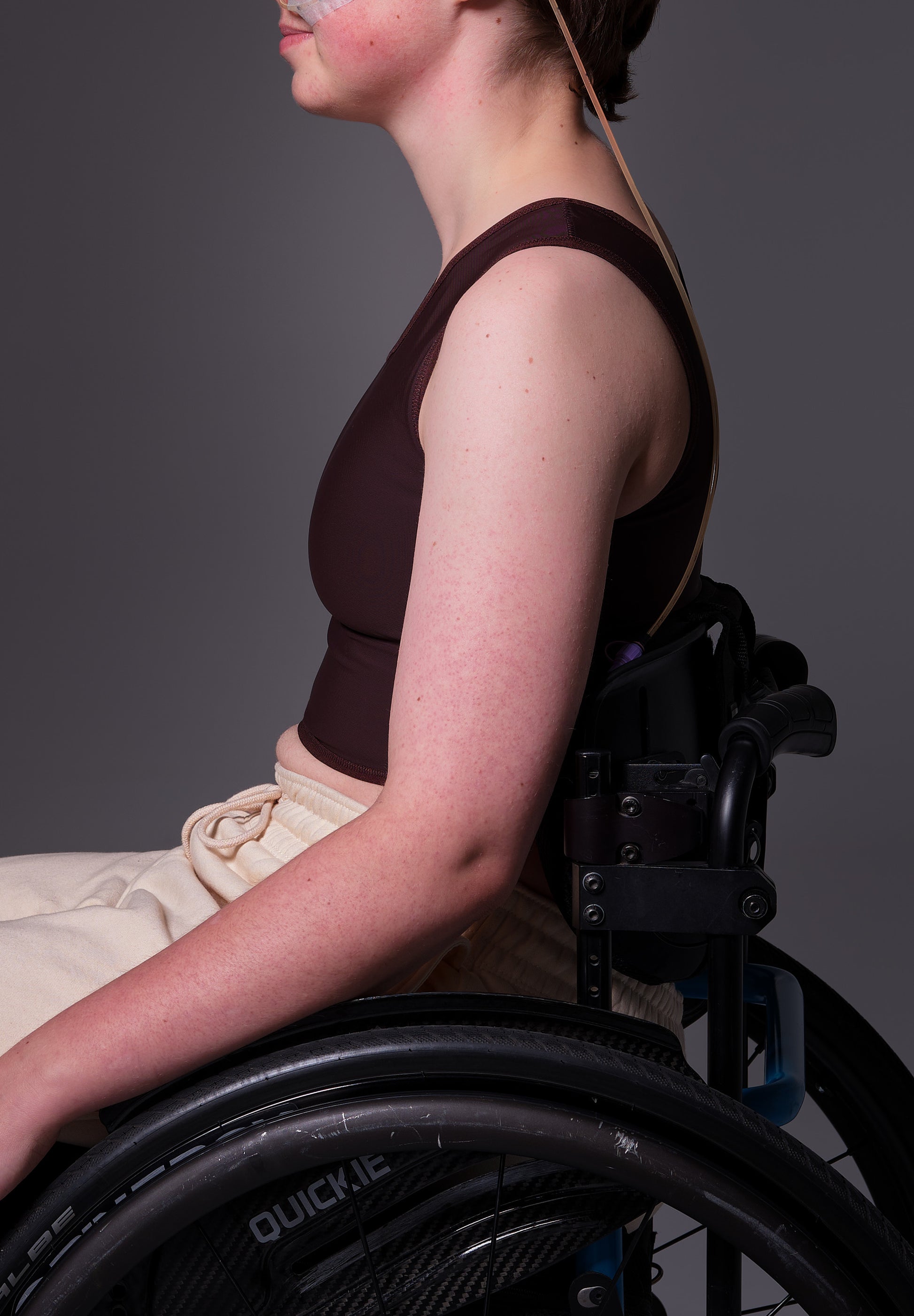 Short Binder extra strong brown as seen from the side on model Brecht in the wheelchair