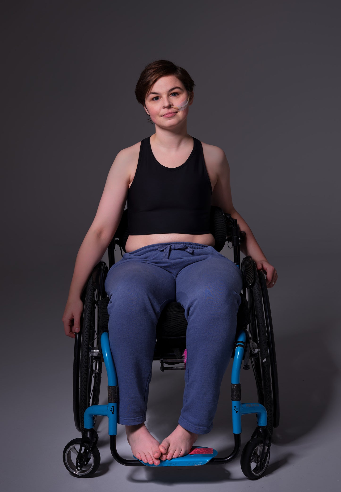 The Tank Binder in black on model Brecht, showing the front, Brecht is sitting in a wheelchair