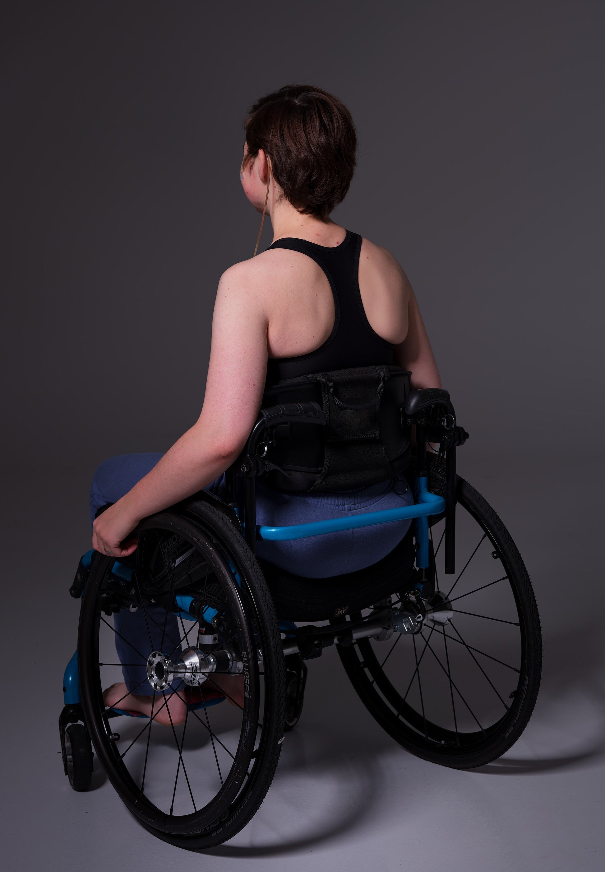 The back of the Tank Binder by UNTAG, model Brecht is wearing the item, sitting in a wheelchair