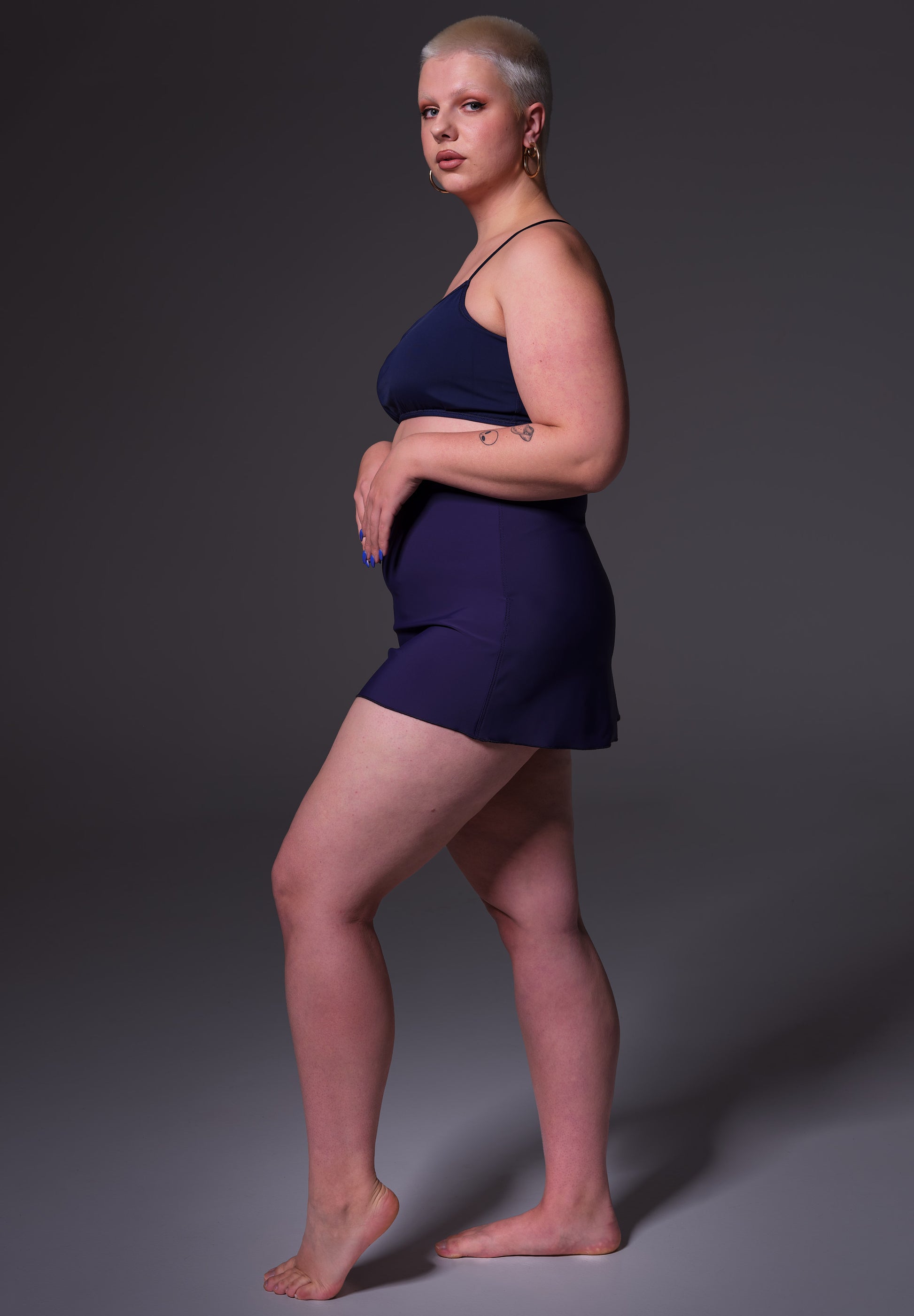 Side view of model Sasha, wearing the Swim Skirt dark blue
